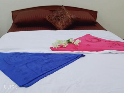 a bed with two pillows and flowers on it at Jack's house Thara in Krabi town