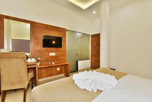a bedroom with a bed and a desk and a television at Hotel sallow International-Hotel Near Golden Temple in Amritsar