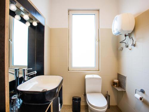 a bathroom with a sink and a toilet and a window at King Fisher Village in Tarrafal