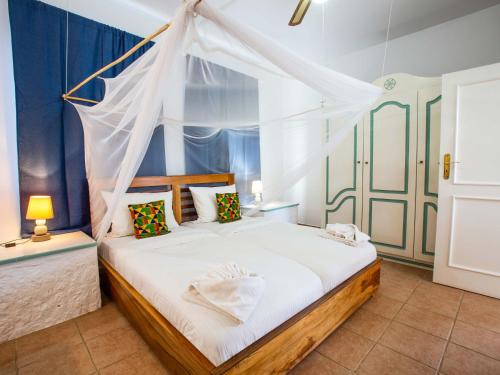 a bedroom with a bed with a mosquito net at King Fisher Village in Tarrafal