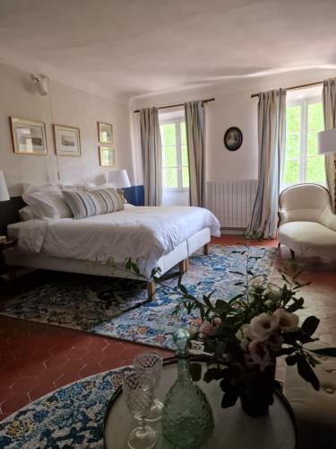 1 dormitorio con 1 cama y 1 mesa con flores en 1560- Domaine Des Cinq Jardins- A Magical and Authentic Mansion en Fuveau