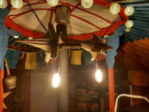 a chandelier hanging from a ceiling with lights at Jurta az erdő mellett dézsával-KERESZ-TANYA in Pilisszentkereszt