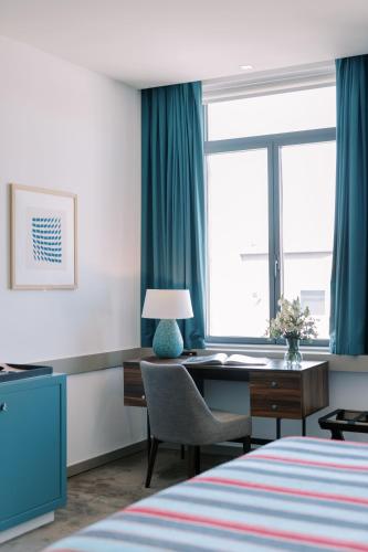 a hotel room with a desk and a window at The Editory Artist Baixa Porto Hotel in Porto