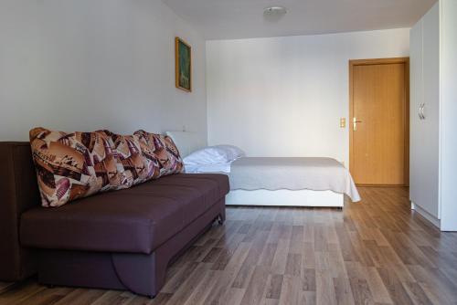 ein Wohnzimmer mit einem Sofa und einem Bett in der Unterkunft Apartments Kim in Rab
