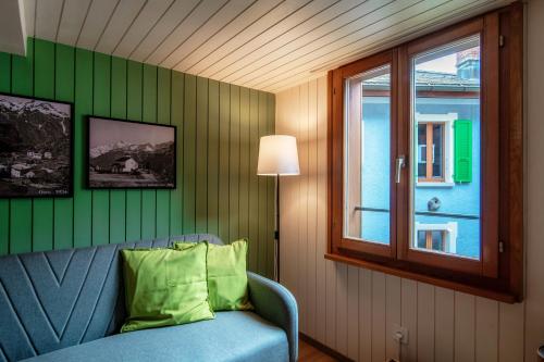 a living room with a blue couch and a window at Casa Bella Oschesina by Quokka 360 - in the village of Osco in Osco