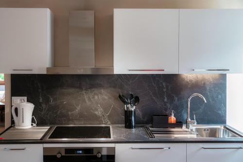 a kitchen with white cabinets and a sink at Casa Bella Oschesina by Quokka 360 - in the village of Osco in Osco