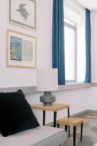 a living room with a table and a lamp at The Editory Artist Baixa Porto Hotel in Porto
