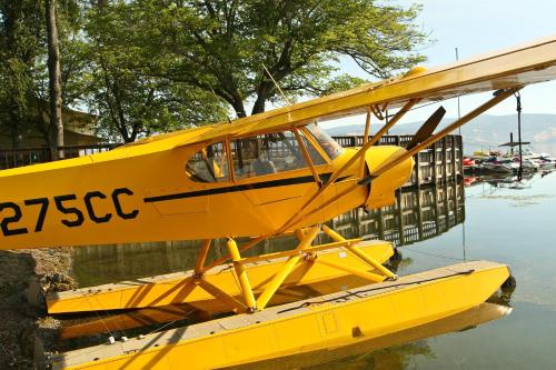 a yellow plane is sitting in the water at Skylark Shores Resort in Lakeport