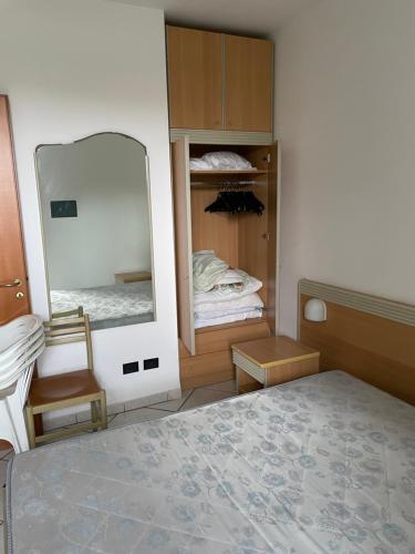 a bedroom with a mirror and a bed and a chair at SALENTO - Casa vacanza - Torre dell’orso in Torre dell'Orso