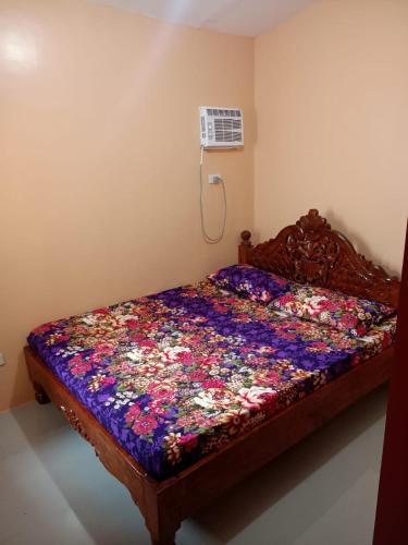 a bed with a floral quilt on it in a room at Paniqui, Tarlac - Madrid in Anao