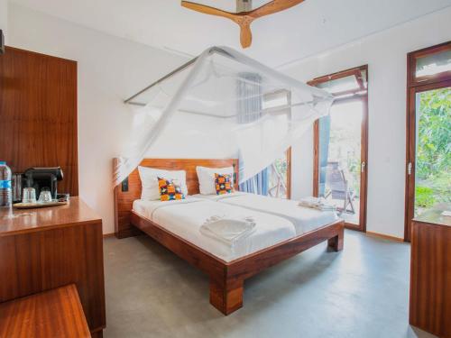 a bedroom with a bed with a mosquito net at King Fisher Village in Tarrafal
