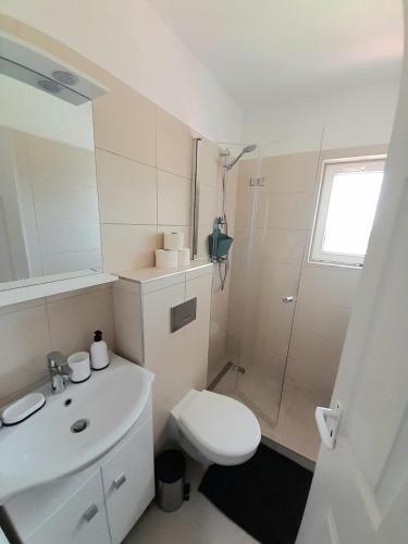 a bathroom with a toilet and a sink and a shower at Sóstói Strand Apartmanház in Siófok
