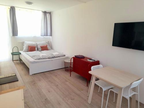 a small room with a bed and a table at Sóstói Strand Apartmanház in Siófok