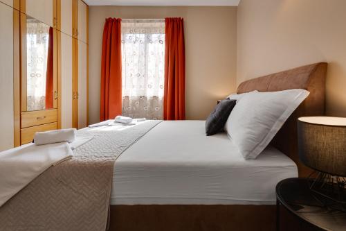 a bedroom with a large white bed with a window at Hotel Sky in Zadar