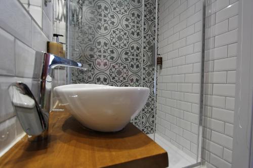 a bathroom with a white bowl sink on a wooden counter at Tyr Winch in Cardiff