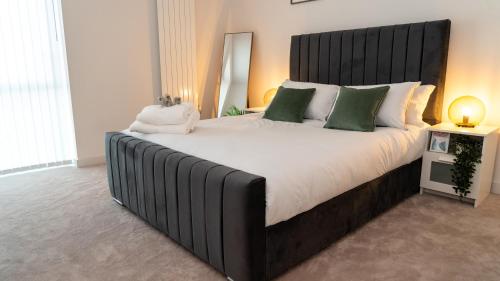 a large bed with a black headboard in a bedroom at Luxury 1-Bed Apartment with River and City view in London