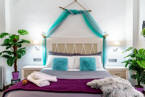 1 dormitorio con 1 cama con dosel azul en My Granada Garden - Mimosa studio, en Granada