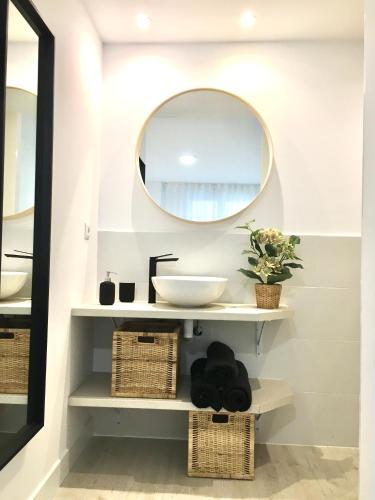 a bathroom with a sink and a mirror at Castro Holidays - Apto C Nuevo Céntrico con Garaje Gratis in Castro-Urdiales