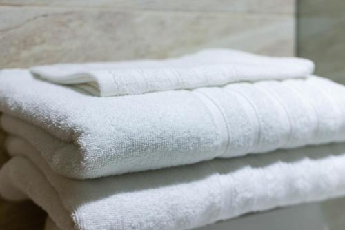 Tres toallas blancas apiladas una encima de la otra. en Casa Bacoba, en Santa Marta