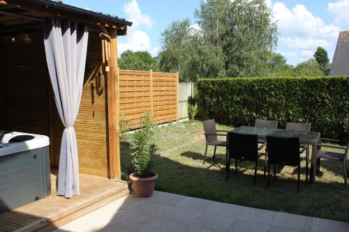 a backyard with a table and chairs and a fence at le coin des hirondelles in Pontorson