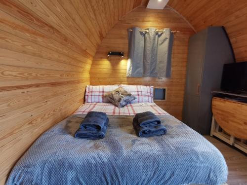 a bedroom with a bed with two blue towels on it at Glamping Pods Nr Port Isaac in Port Isaac