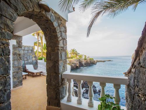 an archway leading to a balcony overlooking the ocean at King Fisher Village in Tarrafal