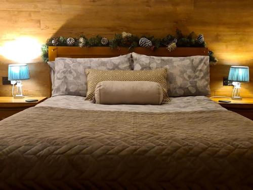 1 dormitorio con 1 cama grande y 2 lámparas en Rowan Tree Lodge with hot tub en Hope Bagot