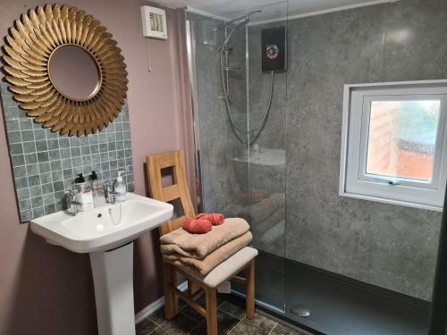a bathroom with a sink and a shower at Rowan Tree Lodge with hot tub in Hope Bagot
