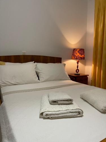 a bedroom with a bed with towels on it at Mama’s Sunshine Garden Villa in Áyios Ilías