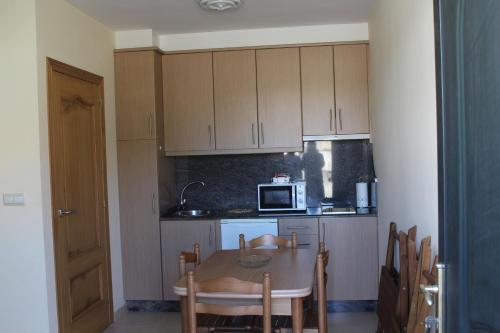 a small kitchen with a table and a microwave at APARTAMENTOS OUTEIRO in A Pobra do Caramiñal