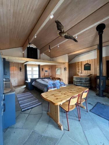 a bedroom with a bed and a wooden table at Toppøy Rorbuer in Reine