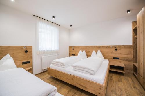 a bedroom with two beds with white pillows at Kuenz Dolomites App 4 in San Candido
