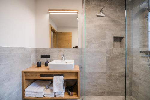 a bathroom with a sink and a shower at Kuenz Dolomites App 4 in San Candido