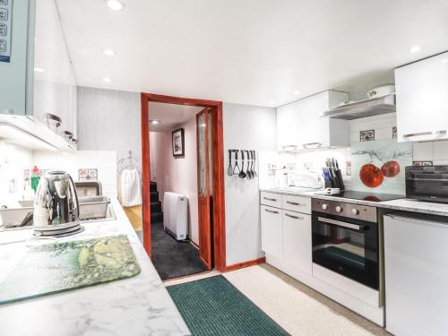 a kitchen with white appliances and a red door at Blairgorm Croft in Nethy Bridge