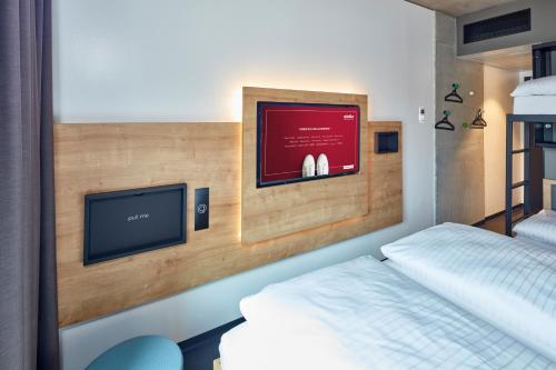 a bedroom with a bed and a flat screen tv at aletto Hotel Potsdamer Platz in Berlin