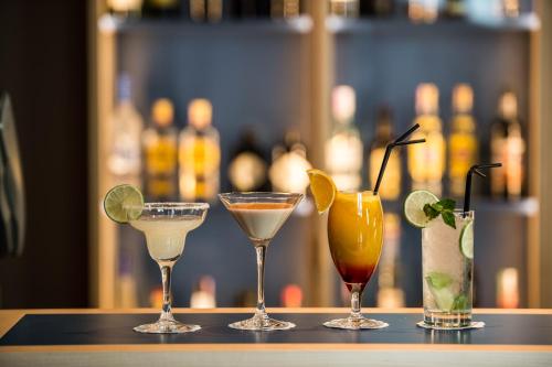 a group of four cocktails sitting on a table at The Editory Artist Baixa Porto Hotel in Porto