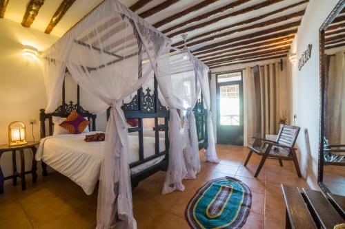a bedroom with a bed with a canopy at Antonio Beach Tree House Hotel & Spa in Uroa