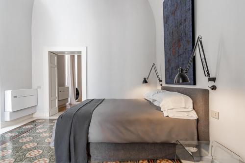 ein weißes Schlafzimmer mit einem Bett und einem Spiegel in der Unterkunft Dimora Bormioli in Bari
