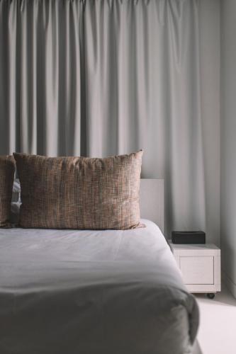 a bed with a pillow on top of it at QUINTA TORRINHA GARDEN Apartment in Funchal