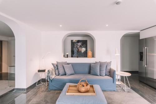 a living room with a blue couch and a table at QUINTA TORRINHA GARDEN Apartment in Funchal