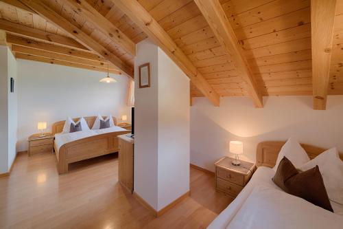 a bedroom with two beds and wooden ceilings at Moarberg in Brunico