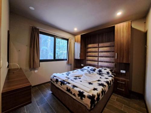 a bedroom with a bed and a desk and a window at Vista Cottage 2 in Ulcinj