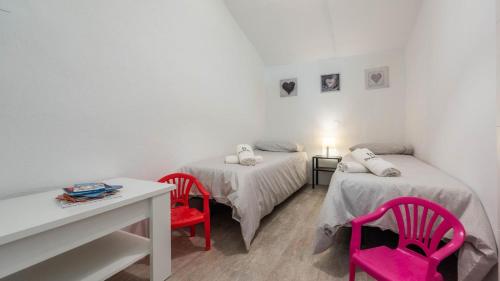 Habitación con 2 camas y 2 sillas rojas. en La Malagueña Rincón de la Victoria by Ruralidays, en Rincón de la Victoria