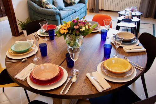 uma mesa de madeira com pratos e um vaso de flores em Residenza Palmina em Rimini