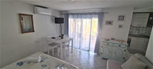 Habitación con cocina con mesa y ventana. en Grazioso monolocale - Rena Majore (Aglientu), en Rena Majore