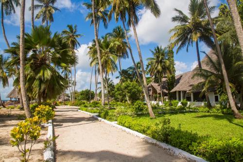 a path in front of a resort with palm trees at Antonio Beach Tree House Hotel & Spa in Uroa