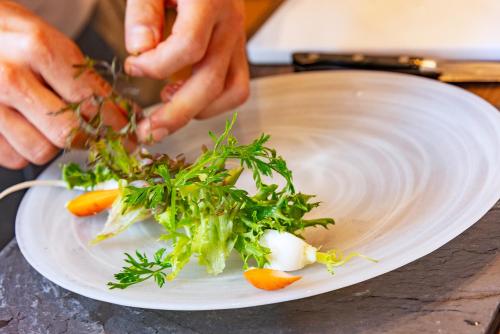 a person preparing a plate of food on a table at plat hostel keikyu kamakura wave in Kamakura