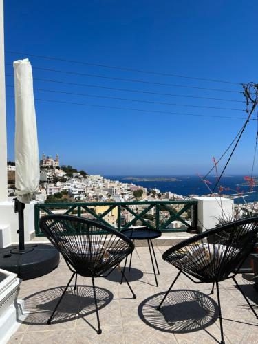 - un balcon avec vue doté de 2 chaises et d'une table dans l'établissement Elia Concept Apartments, à Áno Sýros