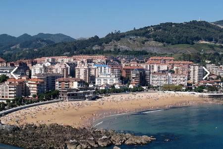 Blick auf einen Strand mit einer Stadt im Hintergrund in der Unterkunft Nuevo Apto A Centrico Terraza Garaje Incluido in Castro-Urdiales