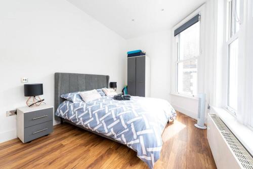 um quarto branco com uma cama e uma janela em Beautiful Apartment by Hyde Park SS2 em Londres
